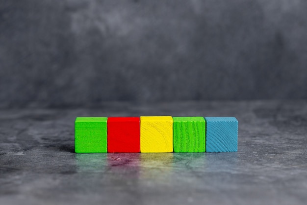 Foto caixas retangulares de cubo de amostra polidas com várias cores, simbolizando estabilidade e desenvolvimento de crescimento alinhado na superfície com diferentes perspectivas delimitadas por acessórios de e-suprimentos