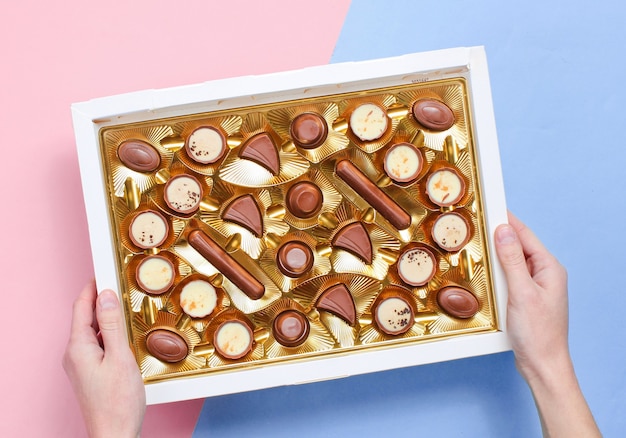 Caja abierta con bandeja dorada de variedad de bombones