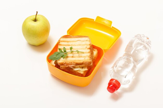 Caja de almuerzo amarilla con rebanadas tostadas de queso de pan y perejil verde