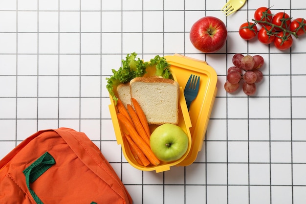 Caja de almuerzo amarilla con verduras y frutas frescas