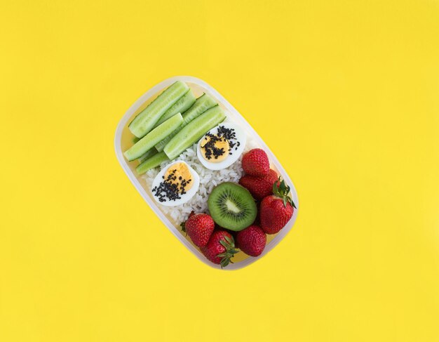 Caja de almuerzo en el fondo amarillo Vista superiorCopiar espacio Primer plano