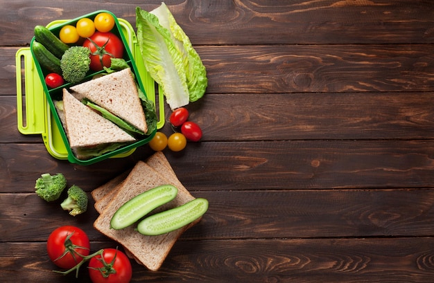 Caja de almuerzo con verduras y sándwich