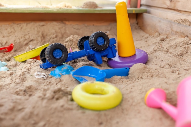 Foto caja de arena de madera para niños con varios juguetes para el juego.