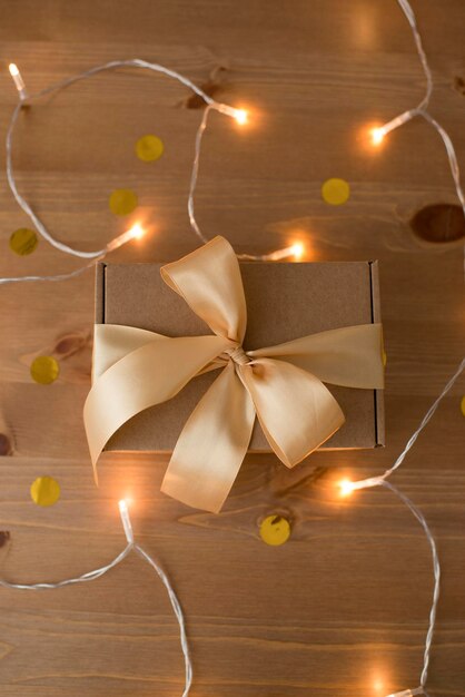 Caja artesanal decorada con cinta sobre mesa de madera, embalaje natural, regalo.