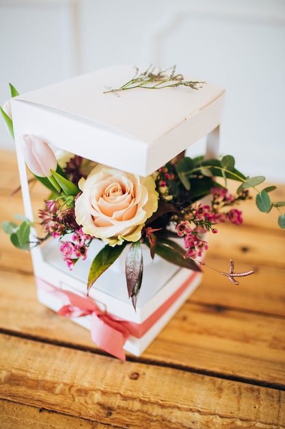 Caja blanca con flores. caja con rosas de peonía y tulipanes blancos. Jardín de flores en macetas. flores silvestres