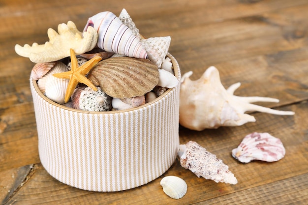 Foto caja blanca llena de regalos marinos sobre fondo de madera marrón