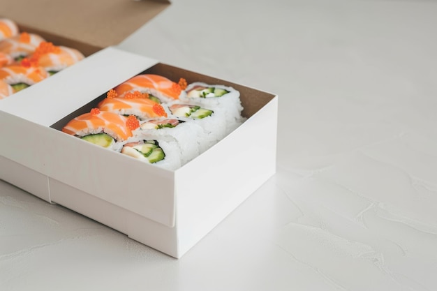 Foto caja blanca llena de sushi en la mesa