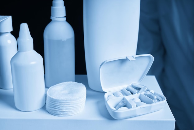 Caja blanca con pastillas y frascos de medicina en blanco