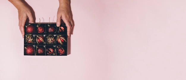 Foto una caja con bolas navideñas en tus manos