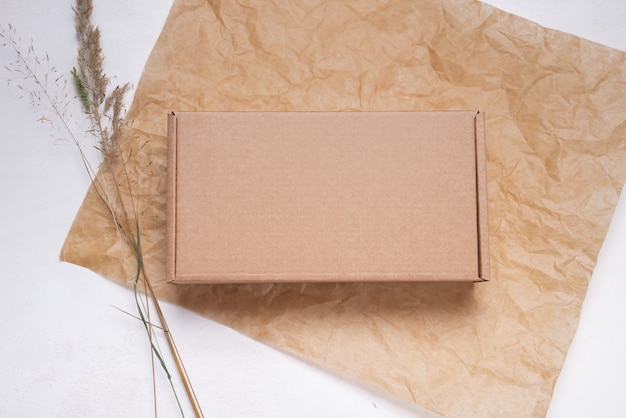 Caja de cartón de cartón plano marrón decorada con hojas secas, vista superior