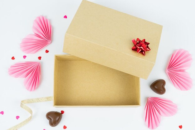 Caja de cartón con corazones de papel y bombones Concepto de San Valentín