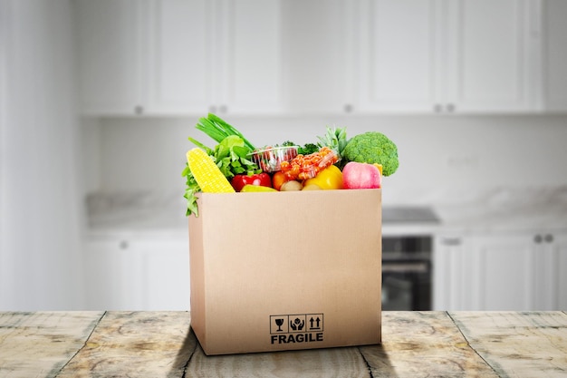 Caja de cartón llena de verduras en la cocina.