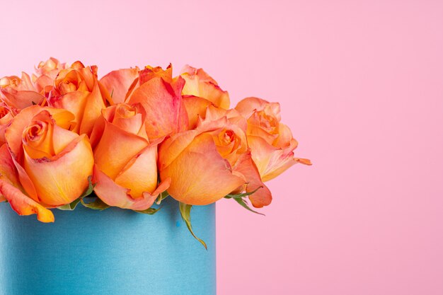 Caja de cartón con rosas sobre fondo rosa