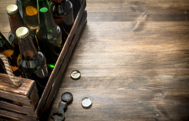 Caja de cerveza fresca en mesa de madera.