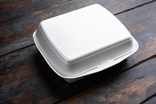 Caja de comida cuadrada blanca para entrega en el fondo de la mesa de madera oscura antigua con espacio de copia para texto