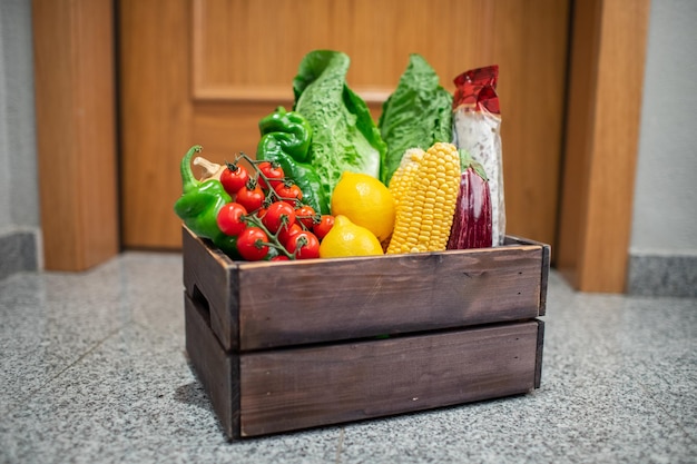 Caja de compras de alimentos en la puerta de la casa o apartamento Entrega de verduras y frutas durante la cuarentena y el autoaislamiento