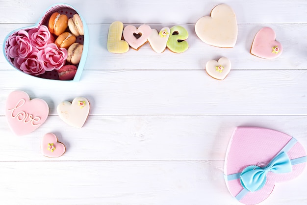 Caja de corazón con Macarons y Rose sobre fondo de madera blanco, día de San Valentín