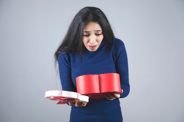 Caja de corazón de mano de mujer sorprendida feliz