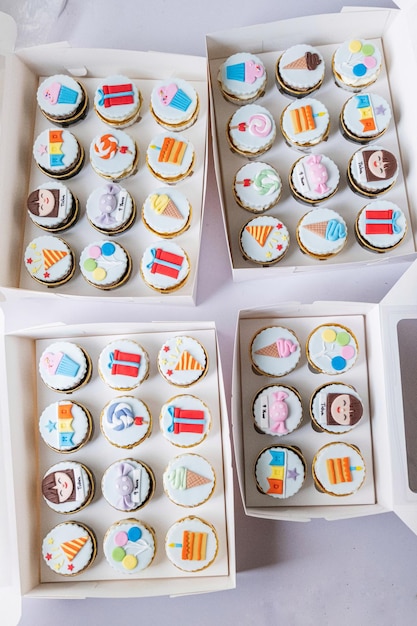 Foto una caja de cupcakes con diferentes diseños en ellos