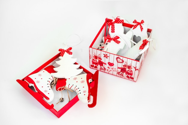 Caja decorativa con juguetes de madera de árbol de Navidad. Árbol de navidad, muñeco de nieve, patines, manopla. Aislado