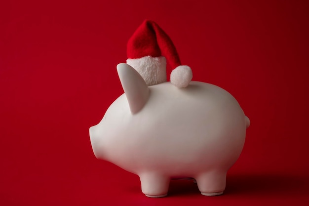 Caja de dinero de la hucha blanca de ahorro de Navidad con un sombrero rojo de santa claus