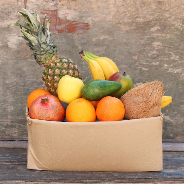 Caja de donación con comida sobre fondo de madera vieja.