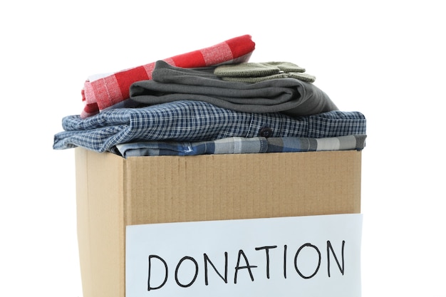 Foto caja de donación con ropa aislado sobre fondo blanco.