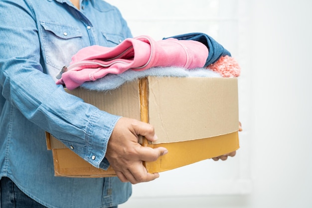 Caja de donación con ropa usada en casa para apoyar la ayuda a las personas pobres en el mundo