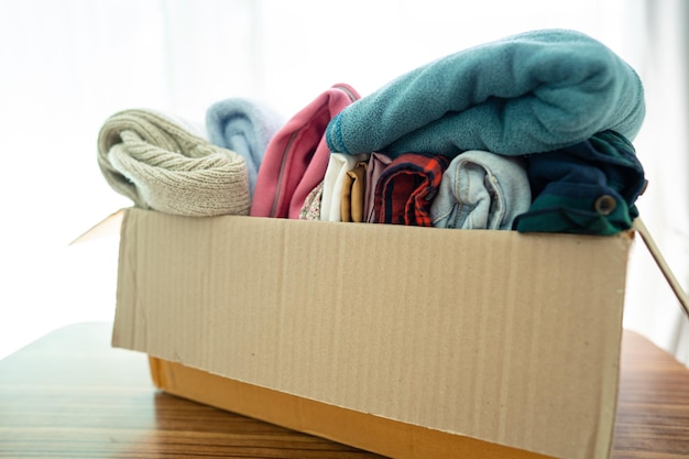 Caja de donación con ropa usada en casa para apoyar la ayuda a los pobres del mundo.