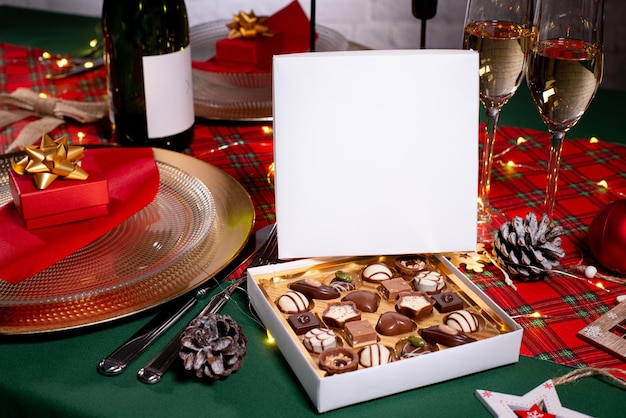 Foto caja de dulces de chocolate navideño sobre una mesa de madera con decoración navideña de temporada