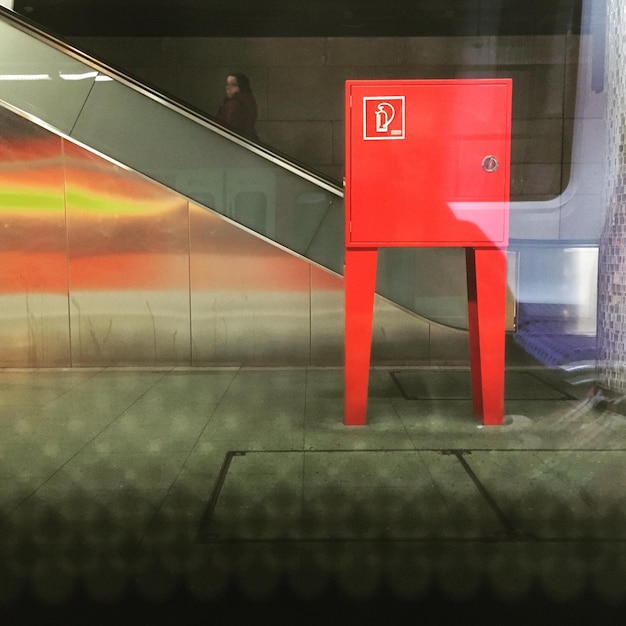 Foto caja eléctrica roja en la estación de tren vista desde el vidrio