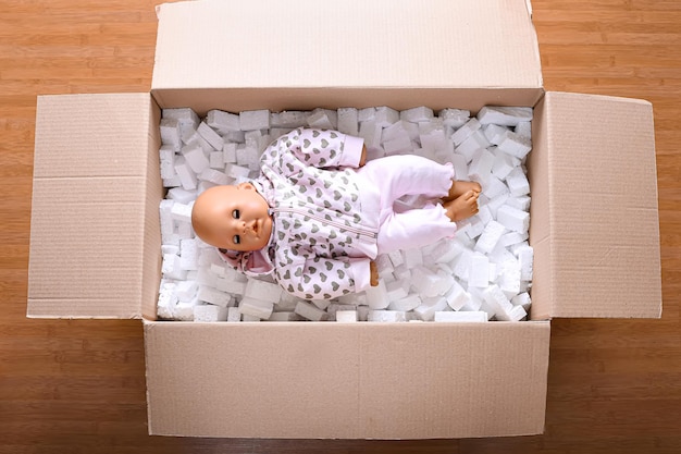 Foto caja de envío con una muñeca dentro