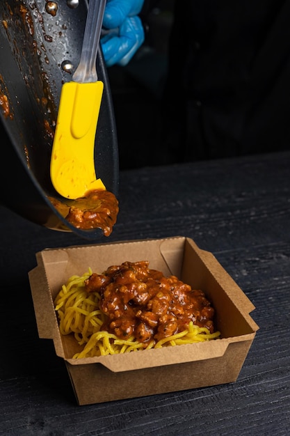 Una caja de espaguetis con salsa de tomate