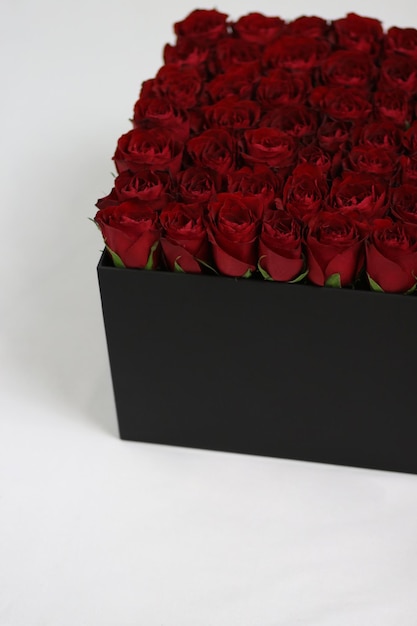 Caja de flores de regalo cuadrada negra con rosas rojas en el interior