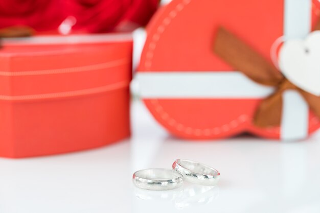 caja en forma de corazón y rosa roja con anillo de bodas