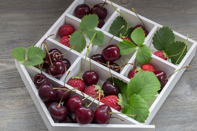 caja de fresas y cerezas de cerca