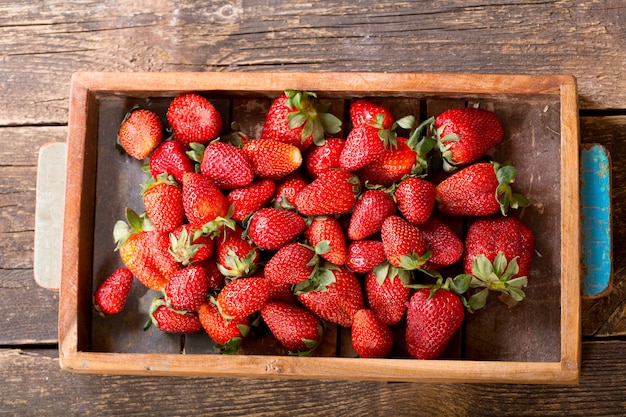 Caja de fresas frescas en una mesa de madera