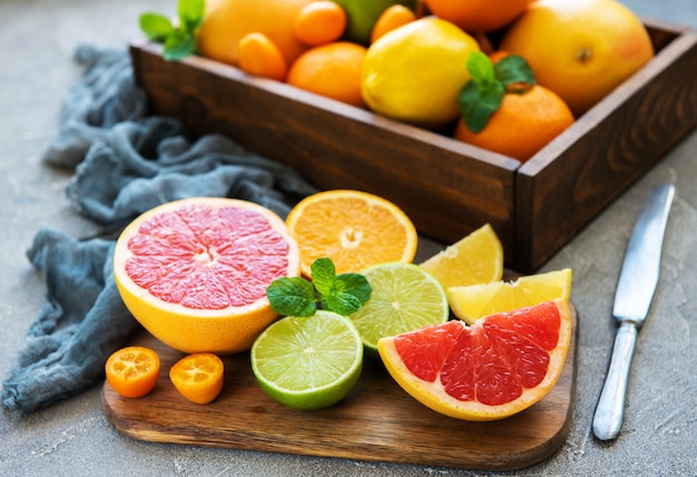 Caja con frutas cítricas frescas sobre un fondo de hormigón.