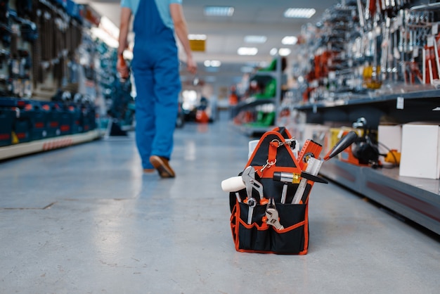 Caja de herramientas en tienda de herramientas, trabajador masculino en uniforme