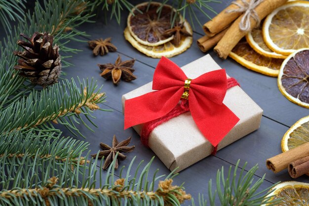 Caja con lazo, especias y ramitas de árbol de Navidad.