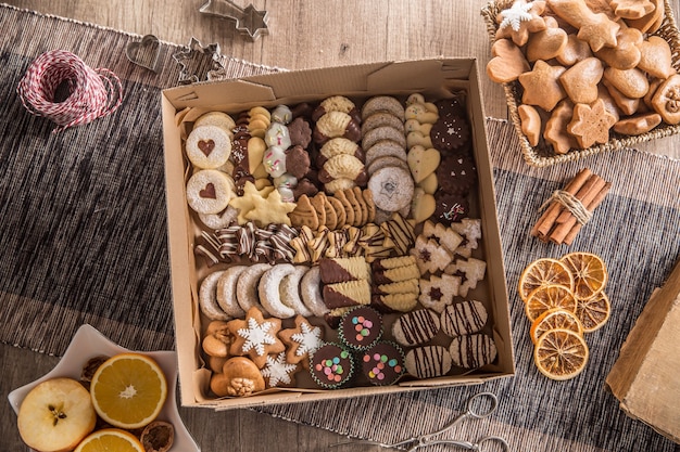 Caja llena de pasteles y cokies dulces navideños.