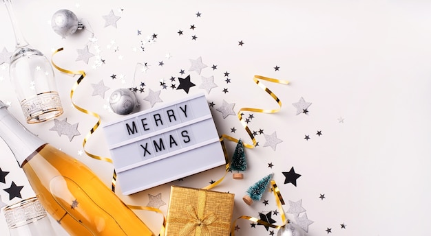 Foto caja de luz con las palabras feliz navidad vista superior en blanco con decoraciones en plano
