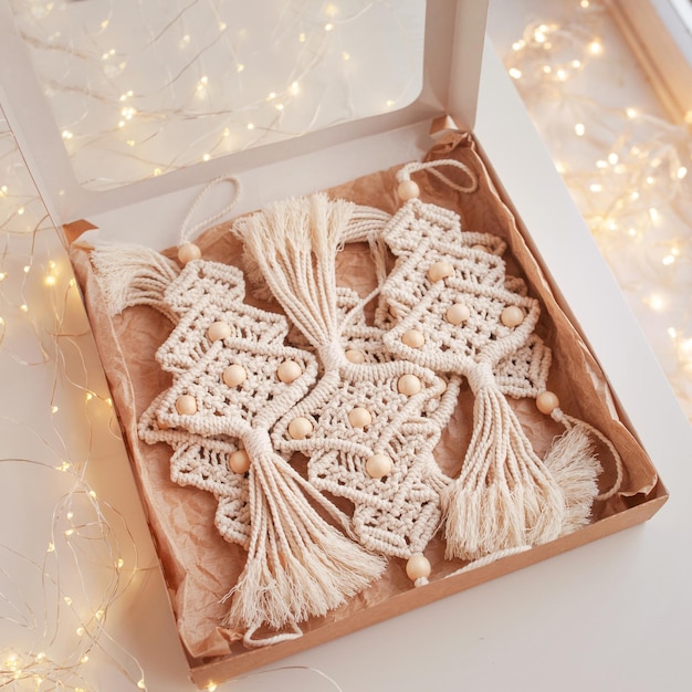 Caja de macramé de Navidad con juguetes de árbol de Navidad Fondo blanco Materiales naturales Hilo de algodón Cuentas de madera y palo Adornos ecológicos Adornos Decoración hecha a mano Vacaciones de invierno y año nuevo