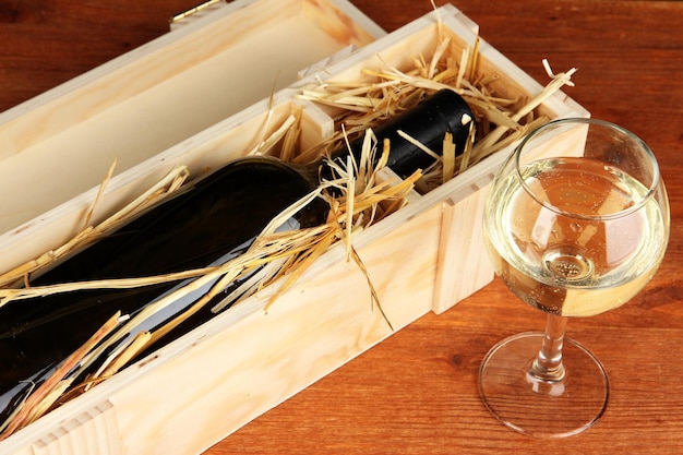 Caja de madera con botella de vino en la mesa