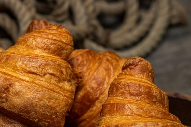 Caja de madera con deliciosos croissants frescos aislados concepto de desayuno francés