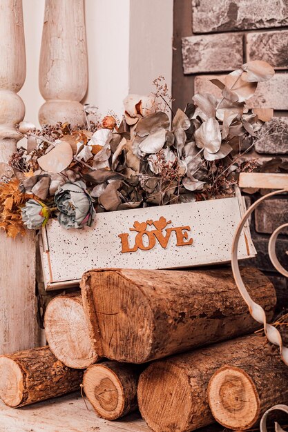 Foto caja de madera con flores secas en la madera cerca de la chimenea amor