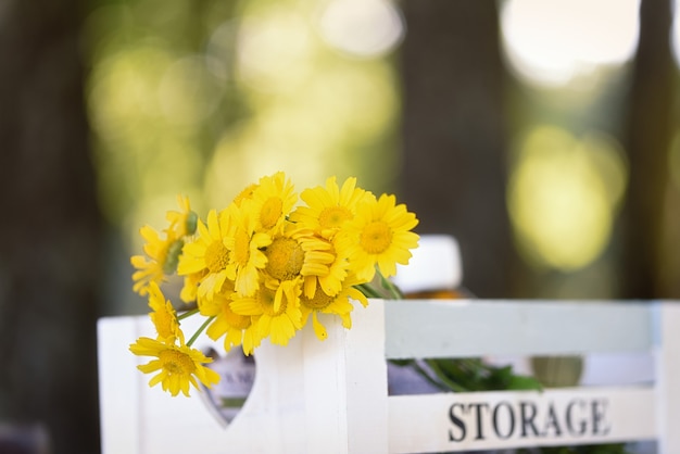 Caja de madera con flores silvestres amarillas. Almacenamiento de texto