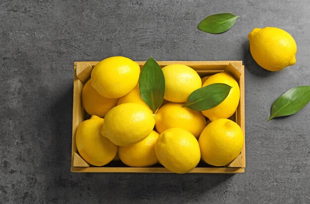 Caja de madera con limones frescos en la mesa