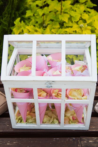 La caja de madera llena de pétalos de rosa al aire libre estilo antiguo