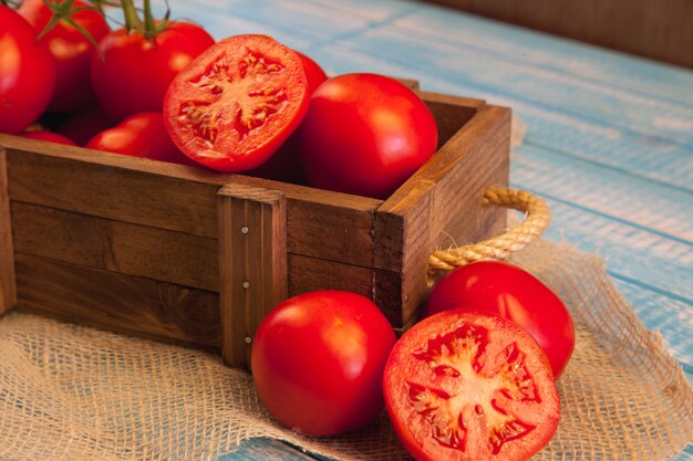 Caja de madera con tomates frescos.